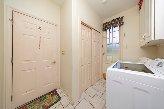 laundry room featuring cabinet space, baseboards, light tile patterned flooring, and washing machine and clothes dryer