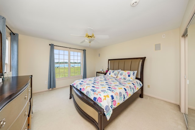 bedroom with baseboards, a ceiling fan, and light colored carpet