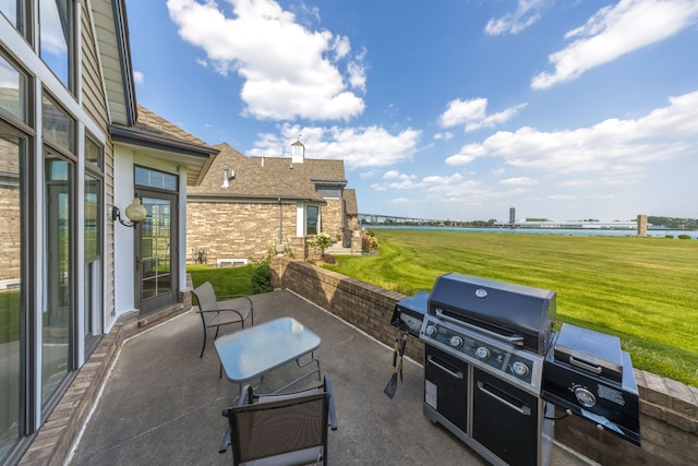 view of patio / terrace with a water view and a grill