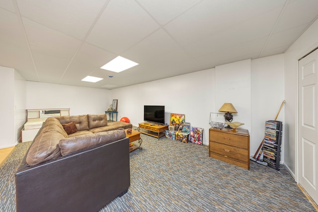 living room with a drop ceiling and carpet flooring