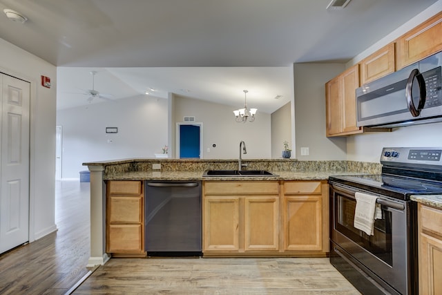 kitchen with light stone counters, stainless steel appliances, a peninsula, a sink, and light wood-style floors