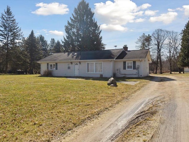 single story home featuring dirt driveway, a chimney, and a front yard