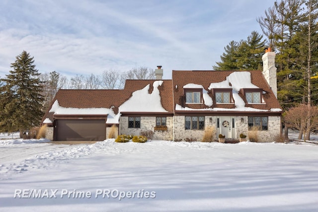 view of front of home with a garage, stone siding, and a chimney