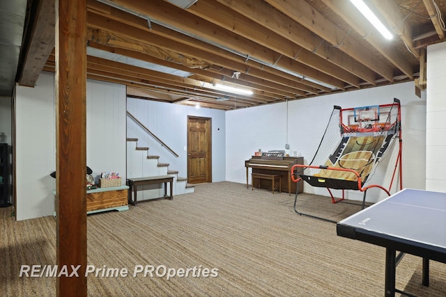 unfinished below grade area featuring stairway, carpet flooring, and concrete block wall