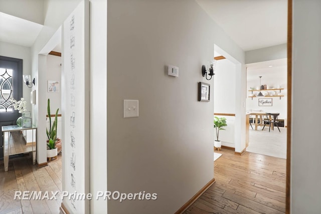 hall featuring hardwood / wood-style flooring and baseboards