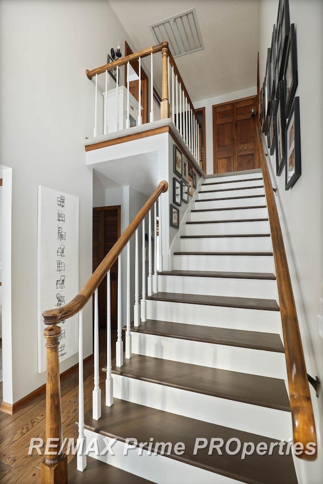 stairway with wood finished floors and baseboards