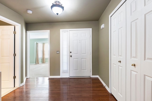 foyer entrance featuring baseboards and dark wood-style floors