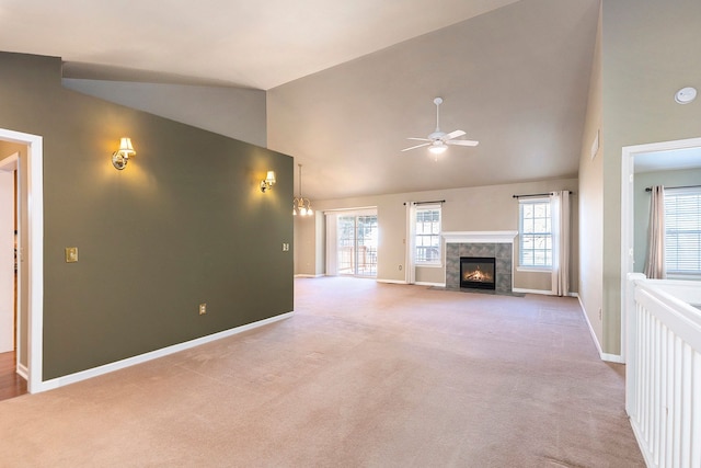 unfurnished living room featuring carpet flooring, a healthy amount of sunlight, a tile fireplace, and a ceiling fan