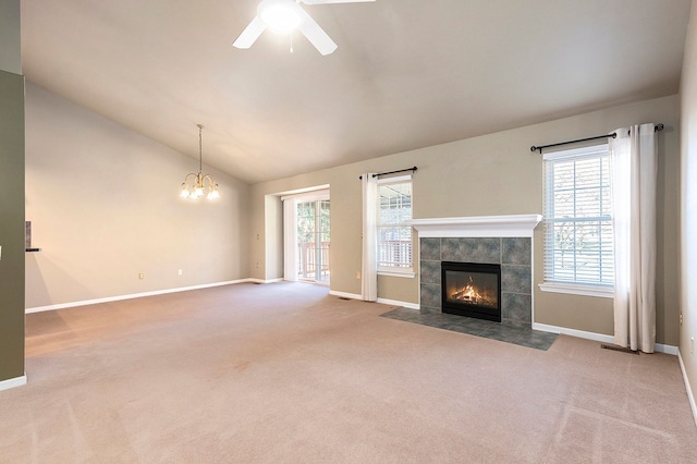 unfurnished living room featuring a tiled fireplace, vaulted ceiling, carpet, and baseboards