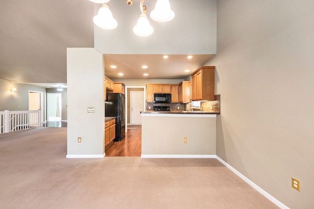 kitchen featuring black appliances, light colored carpet, tasteful backsplash, and baseboards