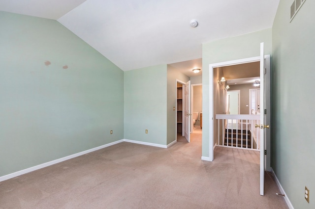 unfurnished bedroom featuring visible vents, baseboards, carpet flooring, and vaulted ceiling