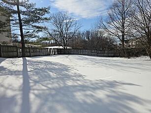 snowy yard with fence