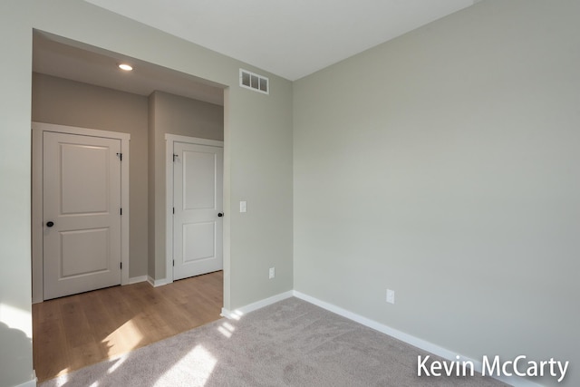 unfurnished bedroom with carpet floors, recessed lighting, visible vents, and baseboards