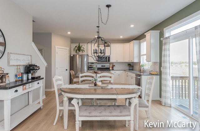 kitchen with tasteful backsplash, visible vents, appliances with stainless steel finishes, a sink, and light wood-type flooring