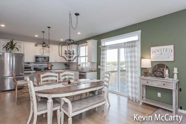 dining space with light wood-style floors, a notable chandelier, and recessed lighting