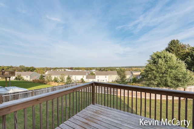 deck with a fenced backyard, a residential view, and a lawn