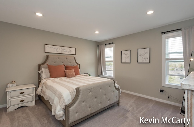 bedroom featuring light carpet, multiple windows, baseboards, and recessed lighting