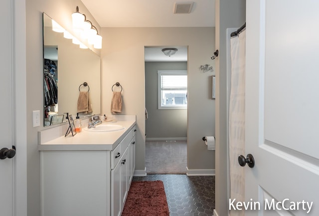 bathroom featuring visible vents, vanity, and baseboards