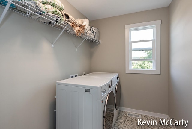 laundry room with laundry area, visible vents, baseboards, tile patterned flooring, and separate washer and dryer