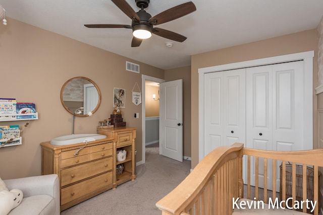 bedroom featuring light carpet, ceiling fan, a closet, and visible vents