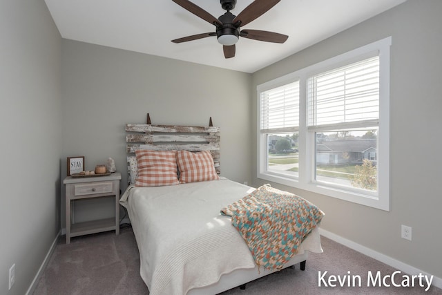 carpeted bedroom with ceiling fan and baseboards