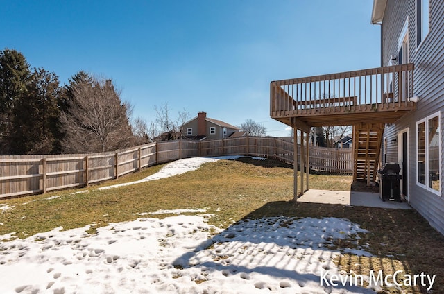 yard layered in snow featuring a fenced backyard, stairway, and a deck