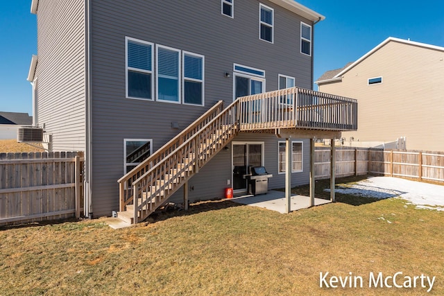 back of property with a patio area, a fenced backyard, stairway, and a lawn