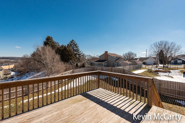 wooden terrace featuring a fenced backyard and a residential view