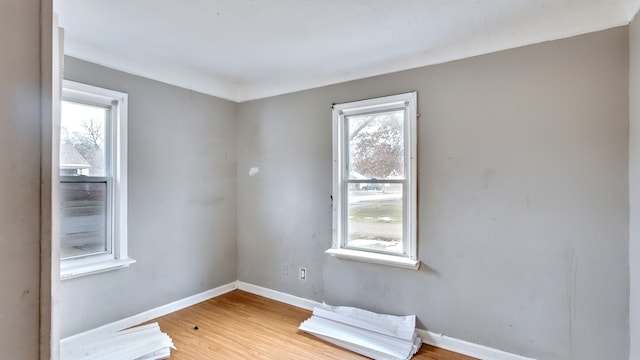 empty room with baseboards and wood finished floors