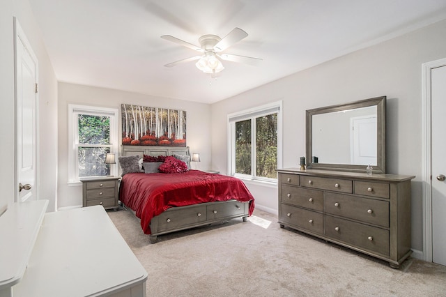 carpeted bedroom with ceiling fan, multiple windows, and baseboards