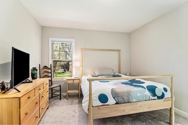 bedroom featuring light carpet and baseboards