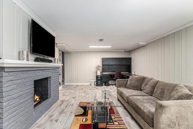 living room featuring a fireplace, visible vents, and wood finished floors