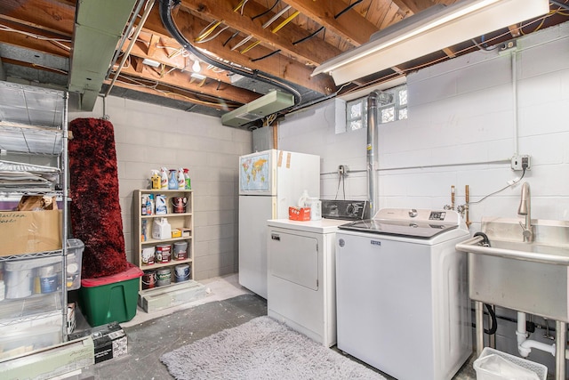 clothes washing area with laundry area, a sink, and independent washer and dryer