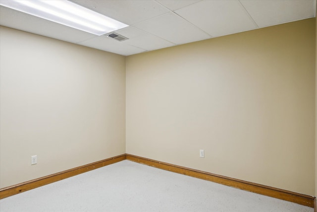 unfurnished room with a paneled ceiling, visible vents, and baseboards