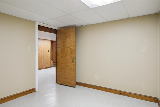 unfurnished room featuring a paneled ceiling and baseboards