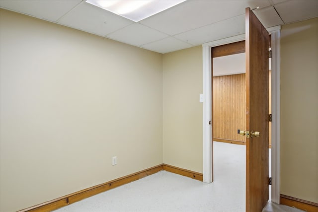 spare room with a paneled ceiling and baseboards