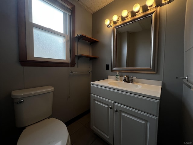 half bathroom with tile patterned flooring, vanity, and toilet