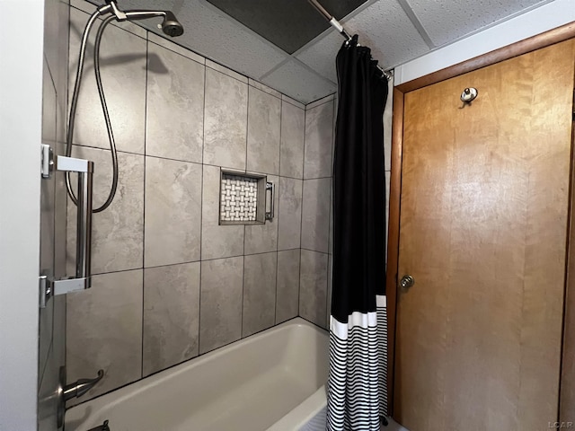 bathroom with a drop ceiling and shower / bathtub combination with curtain