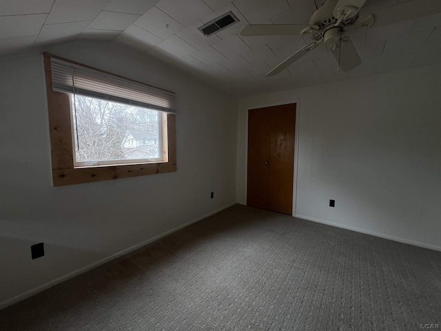 unfurnished room featuring carpet, visible vents, a ceiling fan, vaulted ceiling, and baseboards