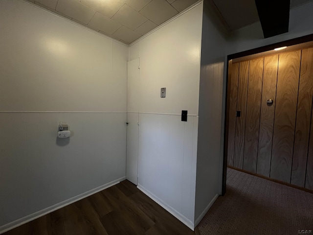 hallway featuring dark wood-style flooring and baseboards