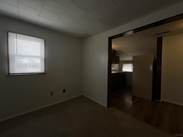 empty room with dark wood-style floors and baseboards