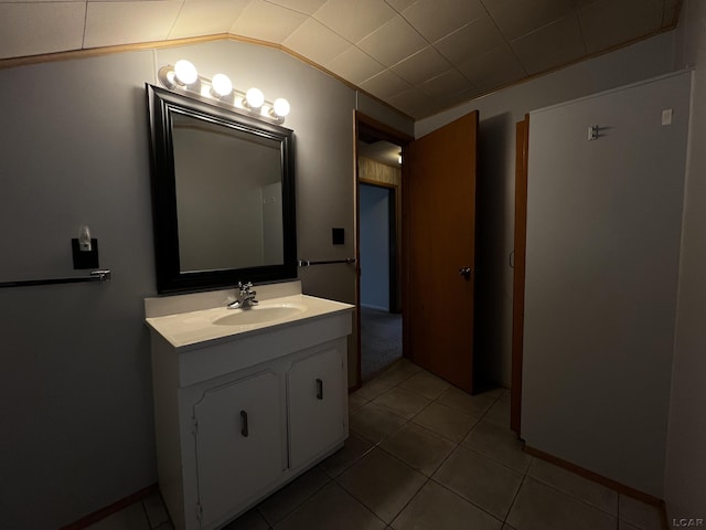 bathroom with lofted ceiling, tile patterned flooring, and vanity