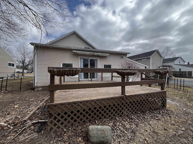 rear view of house with fence and a wooden deck