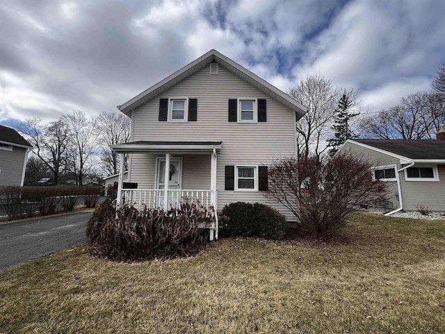 traditional home with covered porch and a front yard