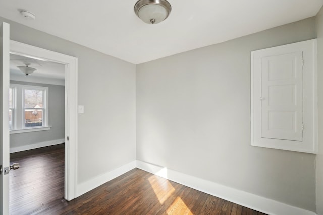 spare room with dark wood-style floors and baseboards