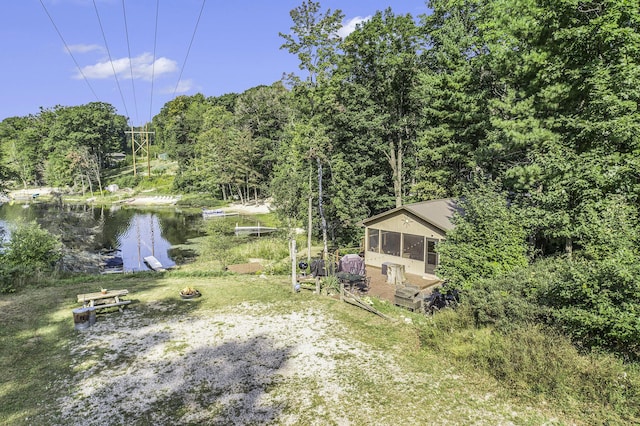 view of yard featuring a water view and a wooded view