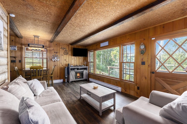 living area with a baseboard heating unit, beam ceiling, a fireplace, and wood finished floors