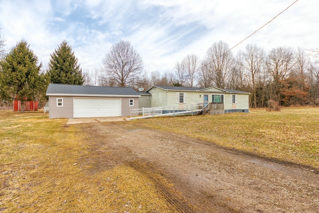 manufactured / mobile home featuring a garage, a front yard, driveway, and an outdoor structure