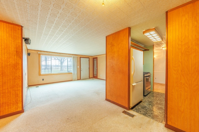 carpeted spare room featuring an ornate ceiling, visible vents, and baseboards