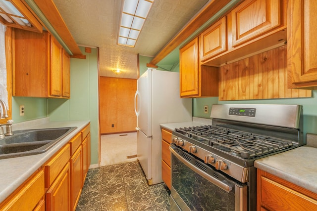 kitchen with brown cabinets, light countertops, stainless steel range with gas stovetop, and a sink